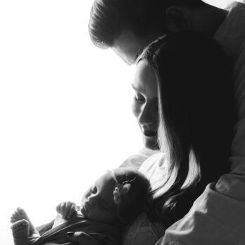 Familie im Gegenlicht, Schwarz Weiß Bild, Eltern mit ihrem Baby in der Hand